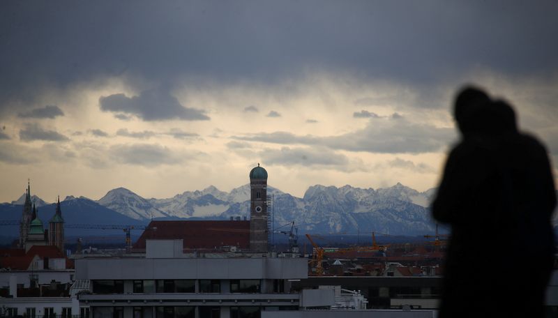 &copy; Reuters. Una persona osserva lo skyline di Monaco di Baviera con lo sfondo delle Alpi a Monaco, 2 marzo 2020. REUTERS/Michael Dalder