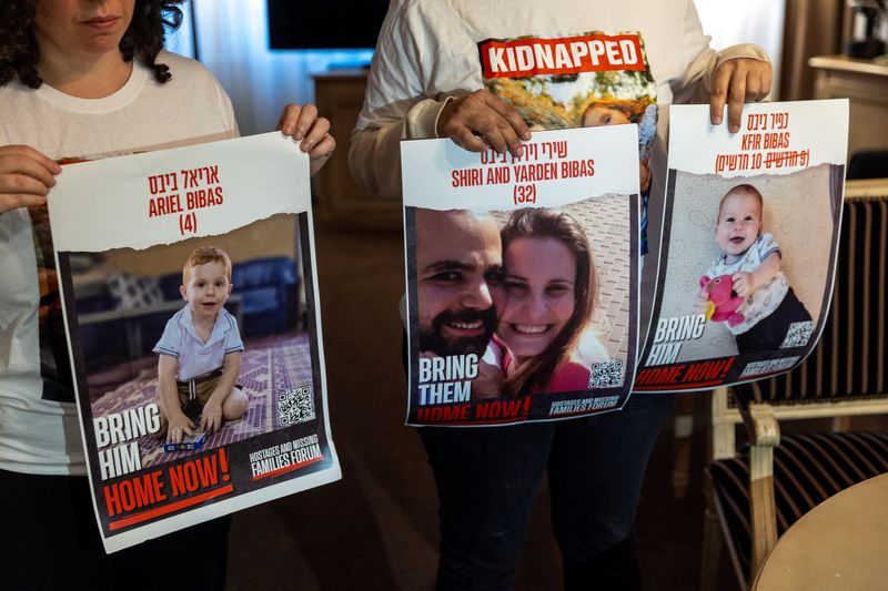 &copy; Reuters. FILE PHOTO: Ofri Bibas Levy, whose brother Yarden (34) was taken hostage with his wife Shiri (32) and 2 children Kfir (10 months) and Ariel (4),  holds with her friend Tal Ulus pictures of them during an interview with Reuters, as the conflict between Isr