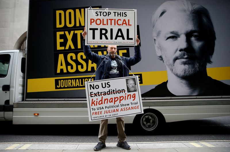 &copy; Reuters. FILE PHOTO: A protestor holds signs outside the Old Bailey, the Central Criminal Court ahead of a hearing to decide whether Assange should be extradited to the United States, in London, Britain September 8, 2020. REUTERS/Henry Nicholls/File Photo