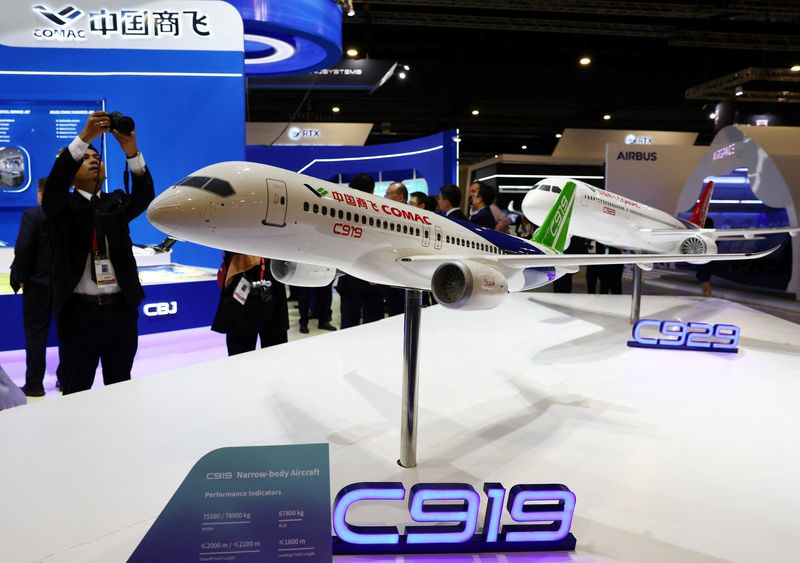 &copy; Reuters. People take photos of a model of the Comac C919 plane during the Singapore Airshow at Changi Exhibition Centre in Singapore, February 20, 2024. REUTERS/Edgar Su