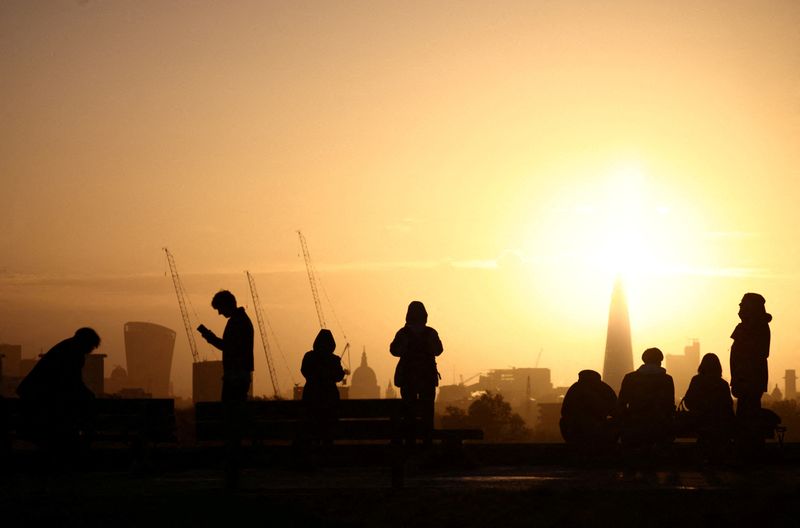 &copy; Reuters. FILE PHOTO: People watch the sunrise behind the city skyline from the top of Primrose Hill in London, Britain, November 25, 2022. REUTERS/Henry Nicholls/File Photo