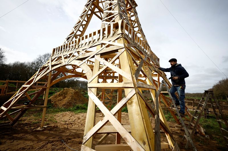 &copy; Reuters. El carpintero francés Frederic Malmezac trabaja en una réplica de 16 metros de la Torre Eiffel construida con madera reciclada que esperan exponer a lo largo del recorrido del relevo de la antorcha olímpica y en los emplazamientos olímpicos de los Jue