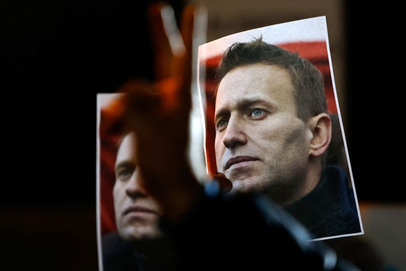 © Reuters. A person gestures in front of portraits of Russian opposition leader Alexei Navalny as people attend a protest and vigil held in front of the Russian embassy following the death of Navalny, in Kappara, Malta, February 19, 2024. REUTERS/Darrin Zammit Lupi
