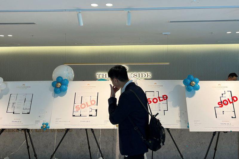 &copy; Reuters. FILE PHOTO: A buyer looks at signs of successful sales of off-the-plan apartments at The Parkside, in Macquarie Park, Sydney, Australia, February 25, 2023. REUTERS/Stella Qiu/File Photo