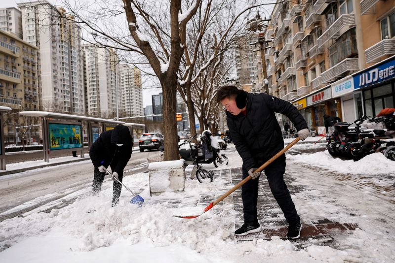 &copy; Reuters. 　２月２１日、中国の首都・北京で大雪があり、当局は高速道路を一部閉鎖した。写真は中国・北京で降雪後に歩行者用道路の雪を取り除く作業員たち。２１日撮影（２０２４年　ロイター