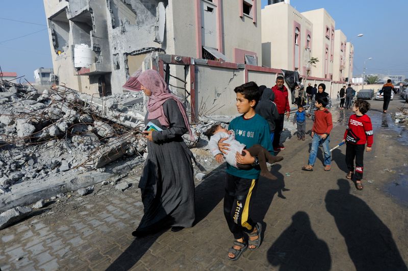 &copy; Reuters. FOTO DE ARCHIVO: Palestinos caminando junto a los escombros de una casa destruida por un ataque israelí, en medio del actual conflicto entre Israel y el grupo islamista palestino Hamás, en Ráfah, sur de la Franja de Gaza. 1 de enero de 2024. REUTERS/Sa