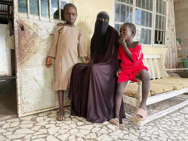 © Reuters. Adama Komma poses sits with her children Aisha, 7 and Hassan, 5 who contracted measles at her home on the outskirts of Banjul, Gambia August 30, 2022. REUTERS/Edward McAllister/FILES