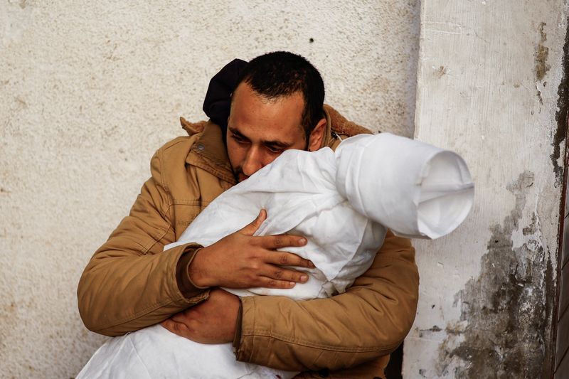 &copy; Reuters. رجل فلسطيني يحتضن جثمان ابنته التي قُتلت جراء إحدي الغارات الإسرائيلية علي غزة في مستشفى أبو يوسف النجار في رفح بجنوب القطاع يوم الأربعاء. ت