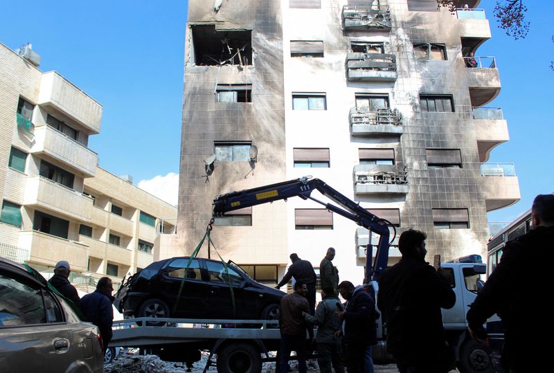 &copy; Reuters. عمال يرفعون سيارة محطمة أمام مبنى تضرر جراء ما قالت وسائل إعلام سورية رسمية إنه هجوم صاروخي إسرائيلي في حي كفرسوسة بدمشق يوم الأربعاء. تصوير