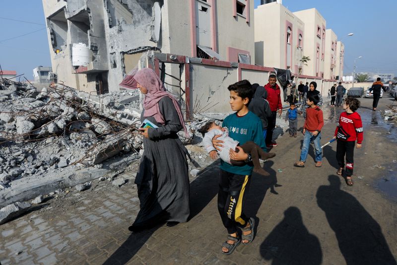 &copy; Reuters. Palestinos caminham em meio a destroços em Rafah, sul da Gaza
 1/1/2024   REUTERS/Saleh Salem