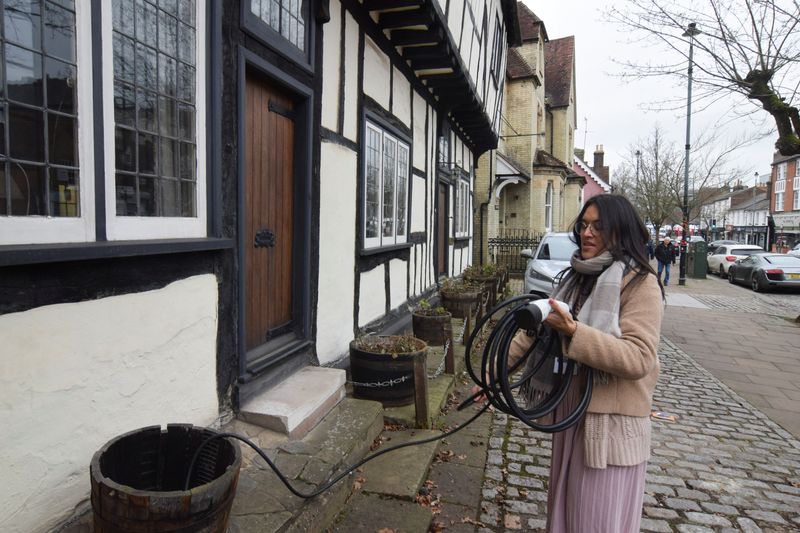 &copy; Reuters. Clare Tan puxa cabo para carregar seu carro elétrico na rua em Berkhamsted, no Reino Unido
31/01/2024
REUTERS/Nick Carey