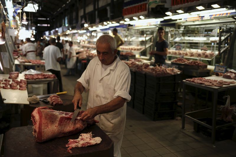 &copy; Reuters. FILE PHOTO: A butcher slices meat as he waits for customers inside Athens' main meat market, Greece August 28, 2015. REUTERS/Stoyan Nenov/File Photo