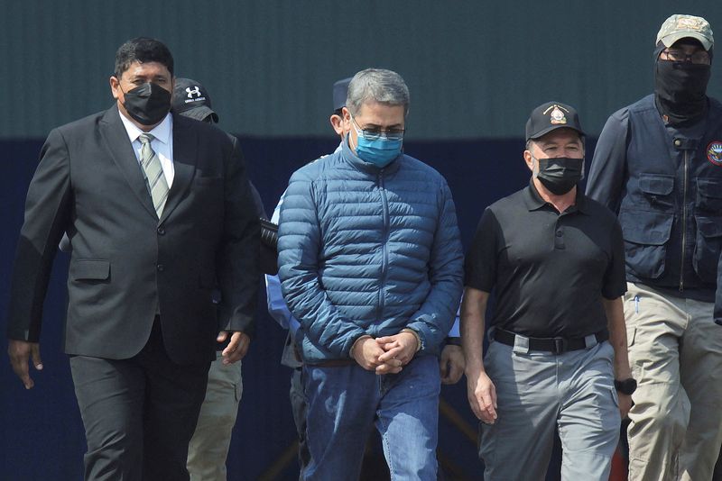 &copy; Reuters. FOTO DE ARCHIVO: El expresidente de Honduras Juan Orlando Hernández es escoltado por las autoridades mientras camina hacia un avión de la Agencia Antidrogas de Estados Unidos (DEA) para su extradición a Estados Unidos, para enfrentar un juicio por carg