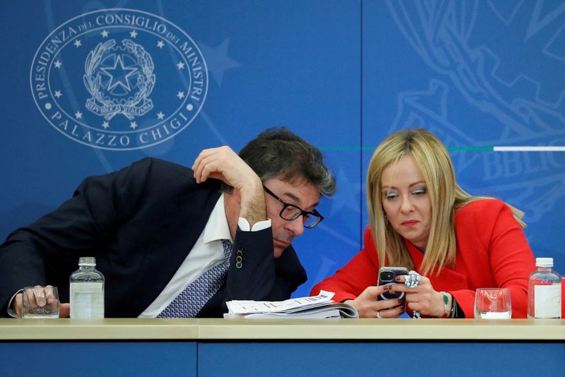 &copy; Reuters. La premier Giorgia Meloni controlla il cellulare con il ministro dell'Economia Giancarlo Giorgetti durante la conferenza stampa per il primo bilancio del suo governo a Roma, 22 novembre 2022. REUTERS/Remo Casilli