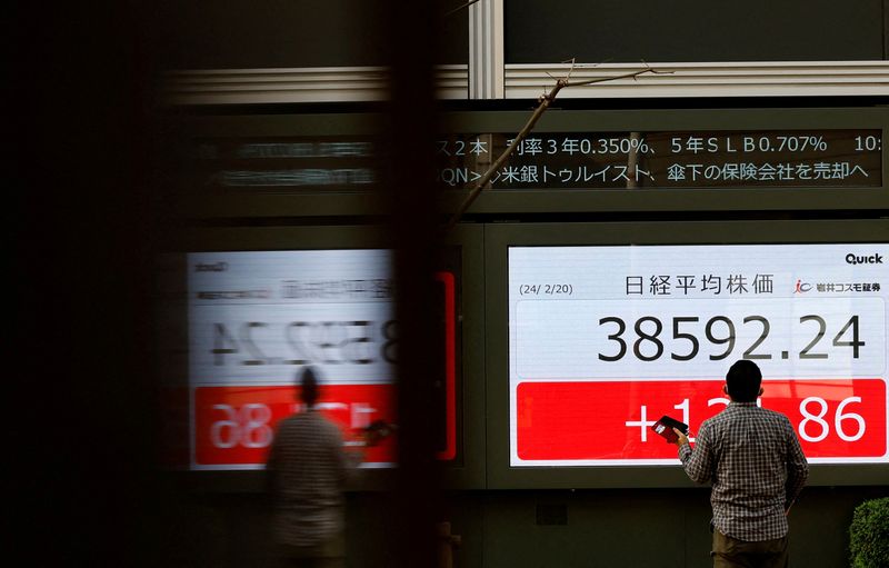 &copy; Reuters. FILE PHOTO: A man looks at an electronic screen displaying Japan's Nikkei share average outside a brokerage in Tokyo, Japan February 20, 2024.  REUTERS/Kim Kyung-Hoon/File Photo