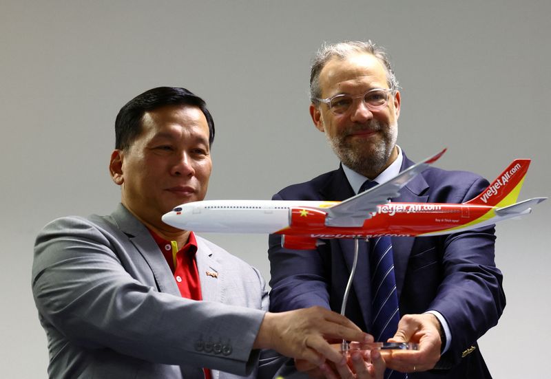 &copy; Reuters. Vietjet’s CEO Dinh Viet Phuong and Airbus EVP Sales Commercial Aircraft Benoit de Saint-Exupery pose for photos during a signing ceremony at the Singapore Airshow at Changi Exhibition Centre in Singapore February 22, 2024. REUTERS/Edgar Su
