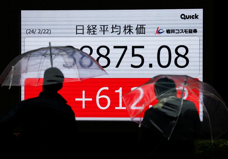 &copy; Reuters. People stand in front of electronic screens displaying Japan's Nikkei share average outside a brokerage in Tokyo, Japan February 22, 2024.  REUTERS/Issei Kato