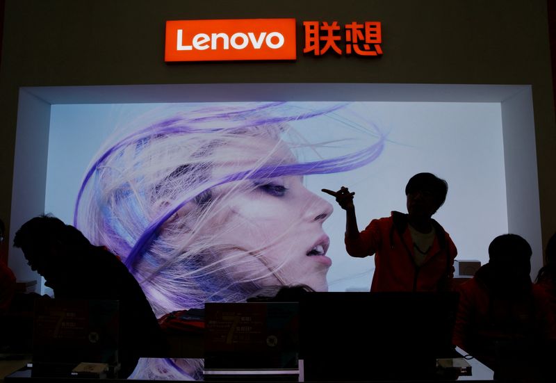 &copy; Reuters. FILE PHOTO: An employee gestures next to a Lenovo logo at Lenovo Tech World in Beijing, China, Nov. 15, 2019. REUTERS/Jason Lee/File Photo