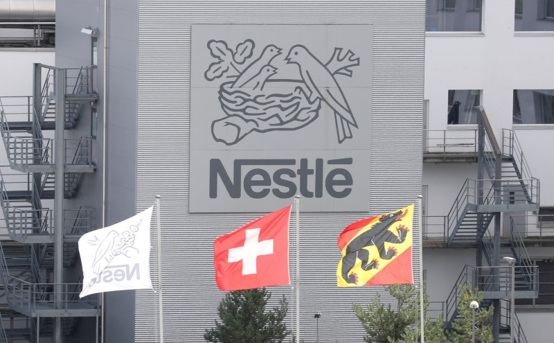 &copy; Reuters. FOTO DE ARCHIVO: Una bandera suiza ondea junto a una bandera del cantón de Berna ante el logotipo de Nestlé en una planta en Konolfingen, Suiza. 28 de septiembre de 2020. REUTERS/Arnd Wiegmann