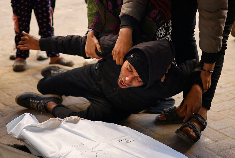 © Reuters. شخص يصرخ بجوار جثمان فلسطيني قتل جراء غارات إسرائيلية في مستشفى أبو يوسف النجار في رفح بجنوب قطاع غزة يوم الخميس. تصوير: إبراهيم أبو مصطفى - رويترز.