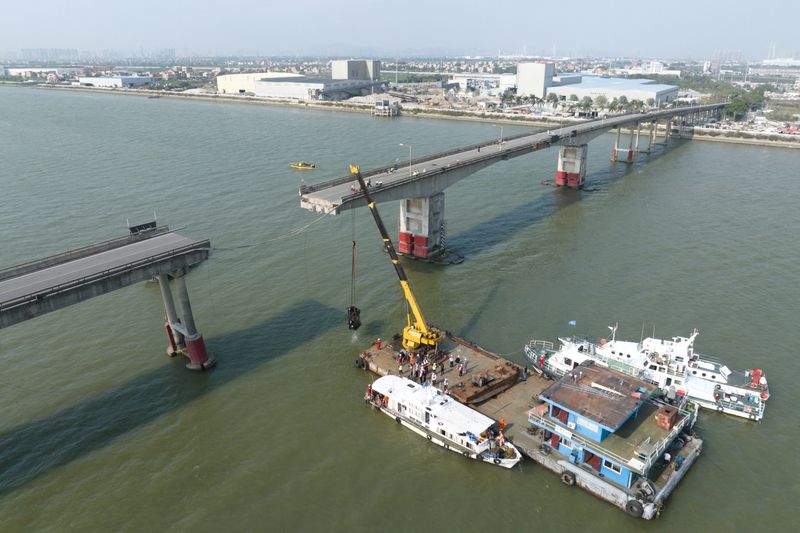 © Reuters. صورة بطائرة مسيرة تظهر عمال إنقاذ في موقع اصطدام سفينة بجسر بالقرب من قوانغتشو في الصين يوم الخميس. صورة لرويترز من تشاينا ديلي. يحظر تداول الصورة داخل الصين.