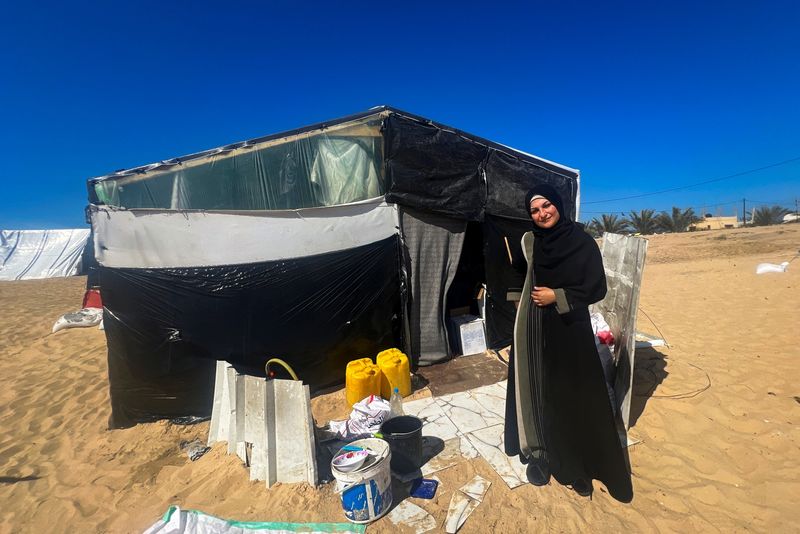 &copy; Reuters. معلمة فلسطينية نازحة من مخيم الشاطئ للاجئين تدعى إيناس الباز تقف خارج خيمتها في رفح بجنوب قطاع غزة يوم الأربعاء. تصوير: صالح سالم - رويترز.