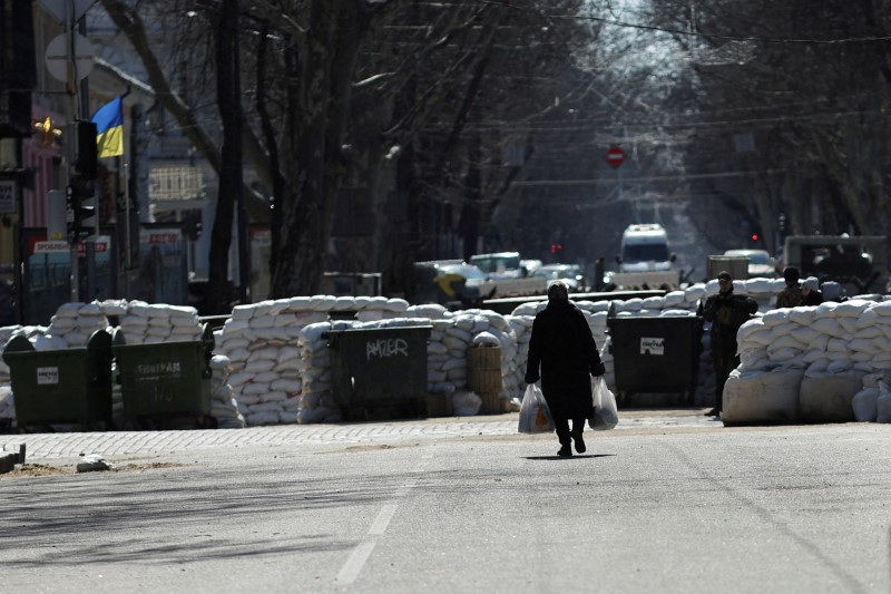&copy; Reuters. FOTO DE ARCHIVO: Una anciana camina cerca de las barreras colocadas en una calle, mientras continúa la invasión rusa de Ucrania, en el centro de Odesa, Ucrania, 17 de marzo de 2022. REUTERS/Nacho Doce