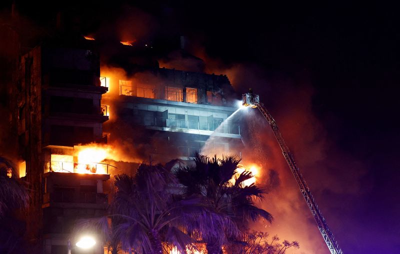 &copy; Reuters. رجال الإطفاء يحاولون إخماد النيران في حريق نشب داخل مبنى سكني في مدينة بلنسية شرق إسبانيا يوم الخميس . تصوير : إيفا مانيز - رويترز . 