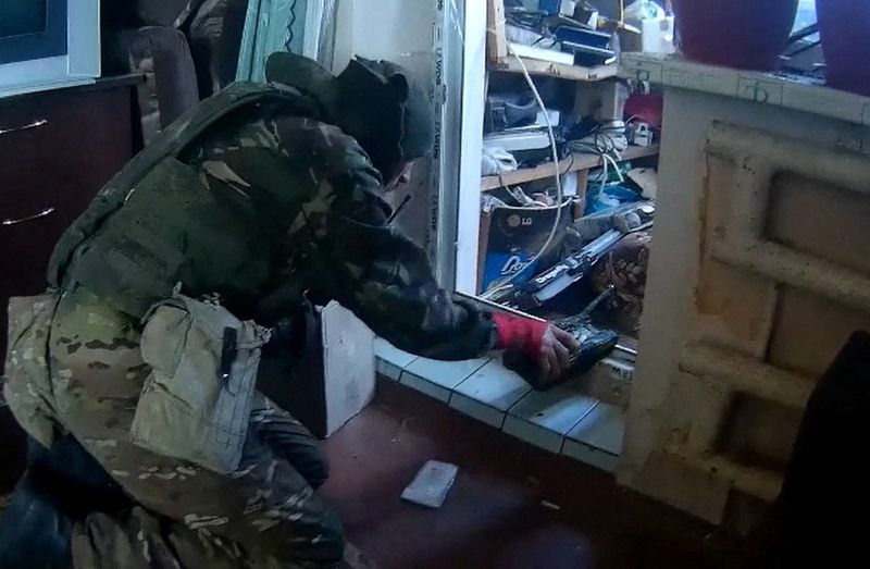 © Reuters. A screengrab from video footage obtained by Reuters shows a fighter from the BARS 9 volunteer force of the Russian military playing with a toy tank he found in an apartment in Balakliia, eastern Ukraine, September 7, 2022. Video obtained by REUTERS 