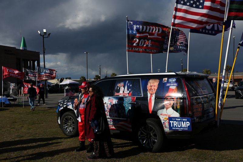 &copy; Reuters. Supporter of former U.S. President and Republican presidential candidate Donald Trump pose in from of a decorated vehicle ahead of his South Carolina Republican presidential primary election night party in Columbia, South Carolina, U.S. February 24, 2024.