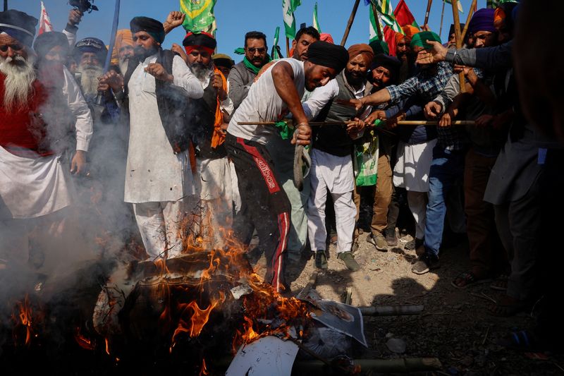 &copy; Reuters. FILE PHOTO: Farmers shout slogans as they burn an effigy of Prime Minister Narendra Modi and other ministers at a protest site, during the march towards New Delhi to push for better crop prices promised to them in 2021, at Shambhu Barrier, the border betw