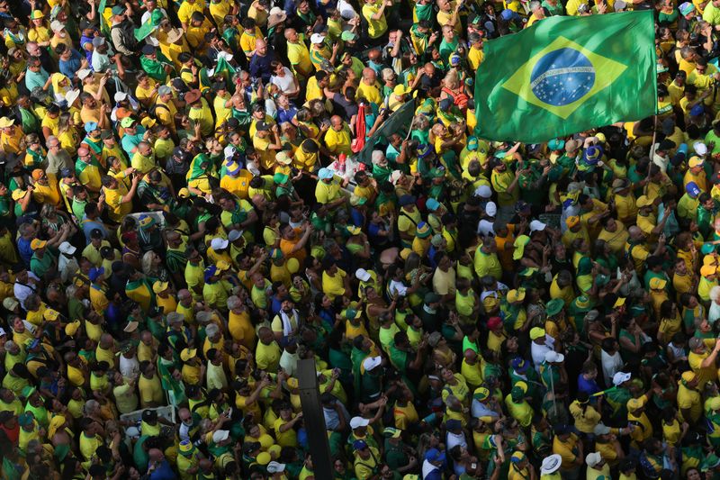 &copy; Reuters. 　２月２５日、ブラジル最大都市サンパウロで２５日、ボルソナロ前大統領の呼びかけで支持者ら数千人が集会を開いた。写真はボルソナロ氏の支持者達。ブラジルのサンパウロで撮影（２