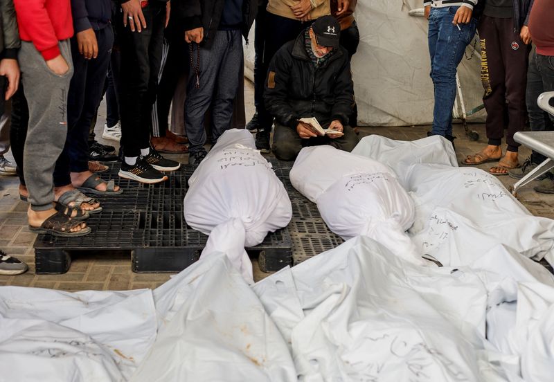 &copy; Reuters. أشخاص إلى جوار جثامين فلسطينيين قتلوا في غارات إسرائيلية في مستشفى أبو يوسف النجار برفح جنوب قطاع غزة يوم 18 فبراير شباط 2024. تصوير: محمد سالم -