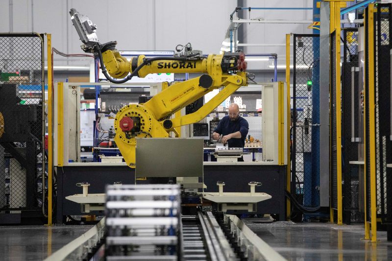 &copy; Reuters. A factory worker works on an aircraft part, as the robot arm of an automated five-axis cell operates autonomously nearby, at Abipa Canada, in Boisbriand, Quebec, Canada May 10, 2023. REUTERS/Evan Buhler/File Photo