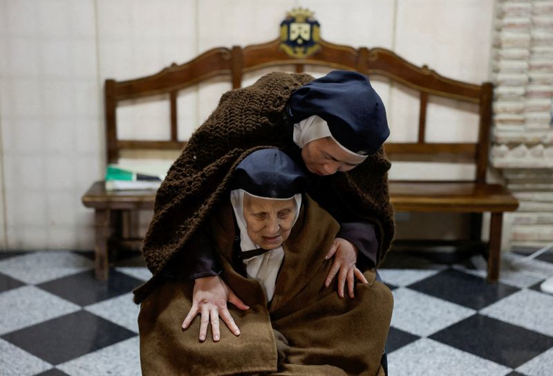 &copy; Reuters. Spanish nun Isabel de la Santísima Trinidad, 83, is embraced by Vietnamese nun Maria Jose de la Eucaristia, 44, two of the four nuns left of the order of Discalced Carmelites, during a mass inside La Merced church at the bottom choir of their convent, wh