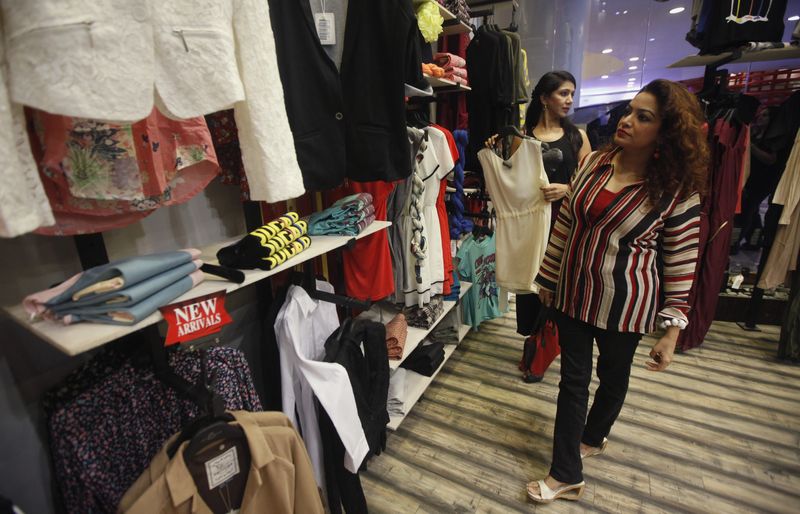 &copy; Reuters. A woman looks at clothes while visiting a shopping mall ahead of Eid al-Fitr in Karachi August 6, 2013. REUTERS/Athar Hussain/file photo
