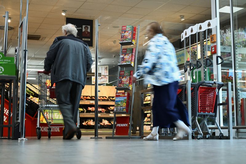 &copy; Reuters. Des personnes passent devant un stand faisant référence à la campagne européenne "coûts réels" menée chaque semaine par le supermarché discount Penny à Berlin. /Photo prise le 1er août 2023/REUTERS/Annegret Hilse