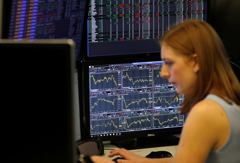 &copy; Reuters. FILE PHOTO: A financial trader works at their desk at CMC Markets in the City of London, Britain, April 11, 2019.  REUTERS/Peter Nicholls/File Photo