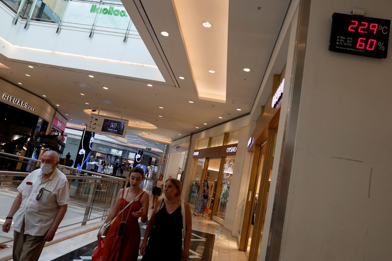 &copy; Reuters. Personas caminan cerca de un termómetro que muestra una temperatura de 22,9 grados centígrados en un centro comercial en Madrid, España, 1 de agosto de 2022. REUTERS/Susana Vera