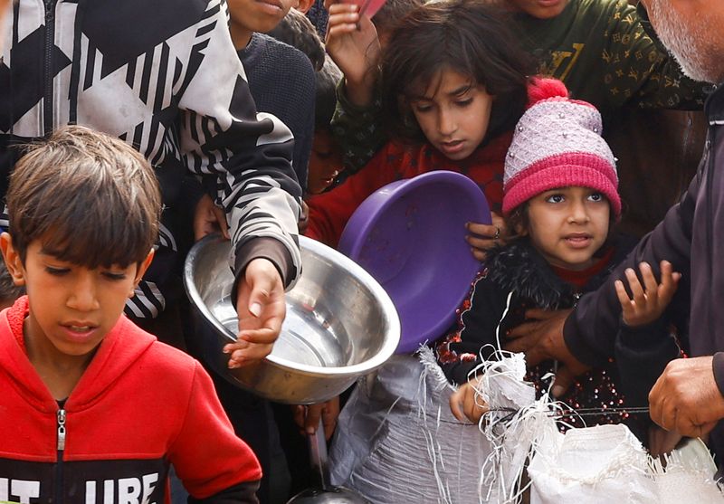 &copy; Reuters. Niños palestinos desplazados esperan para recibir comida gratis en un campamento, en medio de la escasez de alimentos en Rafah, en el sur de la Franja de Gaza. 27 de febrero de 2024. REUTERS/Ibraheem Abu Mustafa