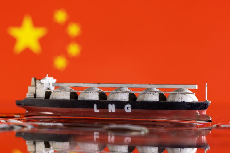 &copy; Reuters. 　２月２８日、仏トタルエナジーズの幹部は、世界の液化天然ガス（ＬＮＧ）需要が２０２４年に拡大するとの見通しを示した。写真は中国の国旗とＬＮＧタンカーの模型。２０２２年５月