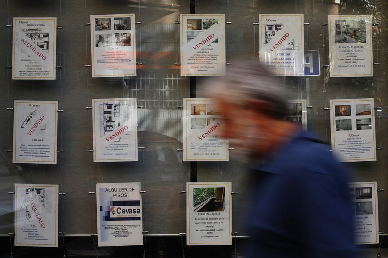 &copy; Reuters. FOTO DE ARCHIVO. Un hombre pasa junto a carteles inmobiliarios que muestran propiedades vendidas en Madrid, España. 8 de septiembre de 2014. REUTERS/Susana Vera