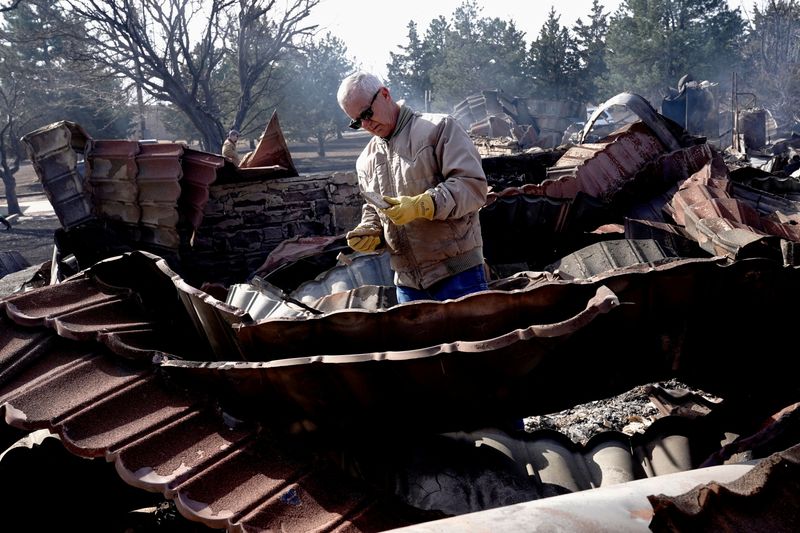 &copy; Reuters. Hugh Lively sifts through the remains of his sisters home that was destroyed by the Smokehouse Creek wildfire, in Canadian, Texas, U.S. February 28, 2024.  REUTERS/Nick Oxford