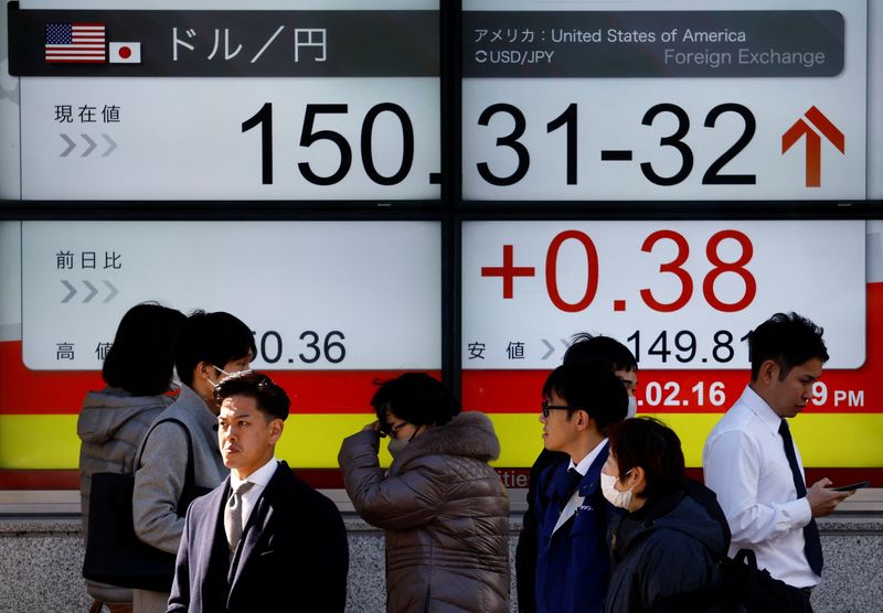 &copy; Reuters. Passersby walk past a screen displaying the Japanese yen exchange rate against the U.S. dollar outside a brokerage in Tokyo, Japan February 16, 2024.  REUTERS/Issei Kato/file photo
