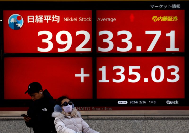 &copy; Reuters. شخصان أمام شاشة إلكترونية تعرض بيانات عن المؤشر نيكي الياباني في طوكيو يوم 26 فبراير شباط 2024. تصوير: إيسي كاتو - رويترز