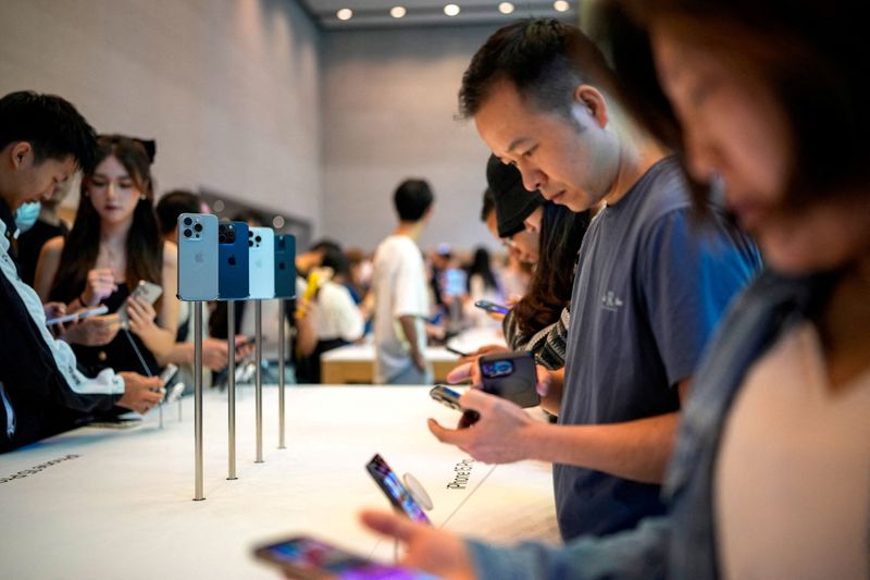 &copy; Reuters. FILE PHOTO: People look at the new iPhone 15 Pro as Apple's new iPhone 15 officially goes on sale across China at an Apple store in Shanghai, China September 22, 2023. REUTERS/Aly Song/File Photo
