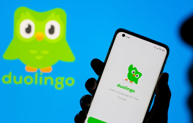 &copy; Reuters. FILE PHOTO: Woman with her smartphone poses in front of displayed Duolingo logo in this illustration taken, June 29, 2021. REUTERS/Dado Ruvic/Illustration/File Photo