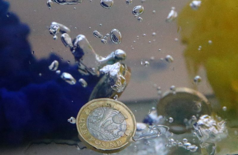 &copy; Reuters. FILE PHOTO: UK pound coins plunge into water coloured with the European Union flag colours in this illustration picture, October 26, 2017. Picture taken October 26, 2017. REUTERS/Dado Ruvic/File Photo