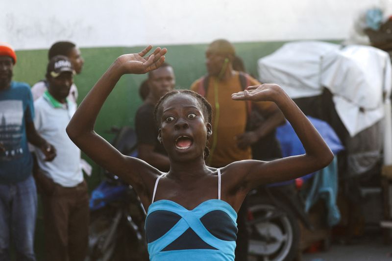 © Reuters. A woman reacts while fleeing her home as police confront armed gangs after prominent gang leader Jimmy Cherizier called for Haiti's Prime Minister Ariel Henry's government to be toppled, in Port-au-Prince, Haiti, February 29, 2024. REUTERS/Ralph Tedy Erol