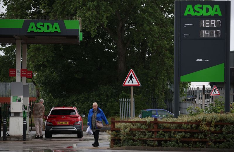 &copy; Reuters. FILE PHOTO: A person puts fuel in their car at a filling station, at an ASDA supermarket in Birkenhead, Britain, July 3, 2023. REUTERS/Phil Noble/File Photo